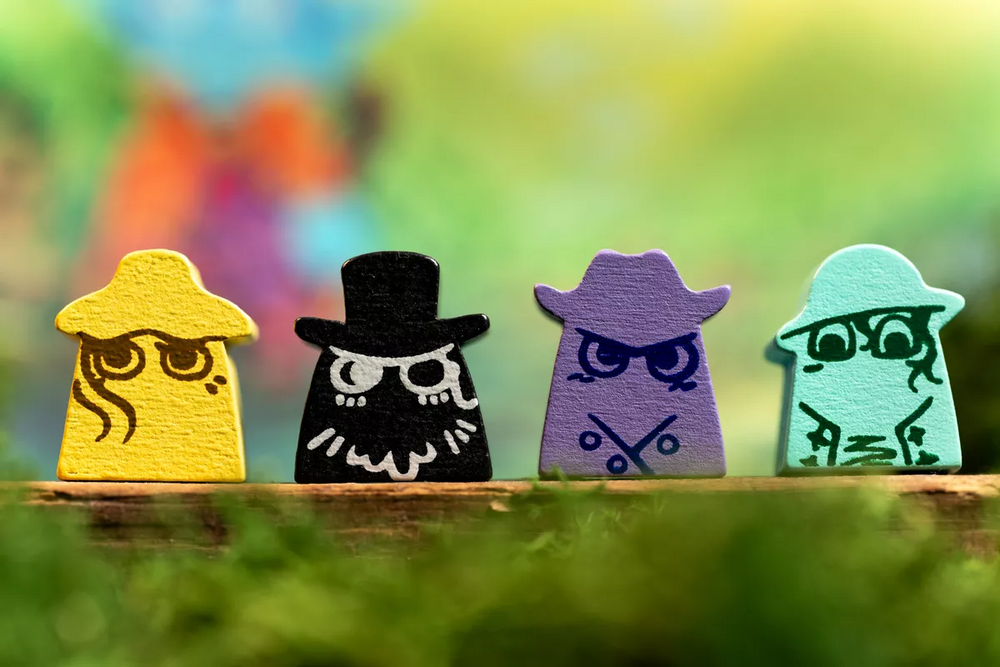 Four colorful wooden figures with unique designs on a blurred natural background