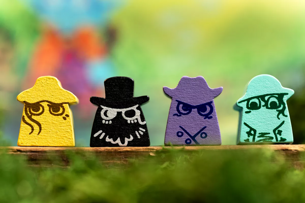 Four colorful wooden figures with unique designs on a blurred natural background