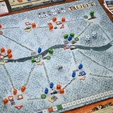 Board game with a map and various game pieces on a wooden table