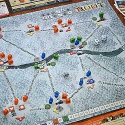 Board game with a map and various game pieces on a wooden table