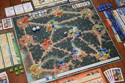 Board game with a detailed map and various game pieces on a wooden table.