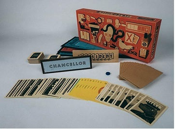 Board game components including cards, a box, and pieces on a gray background